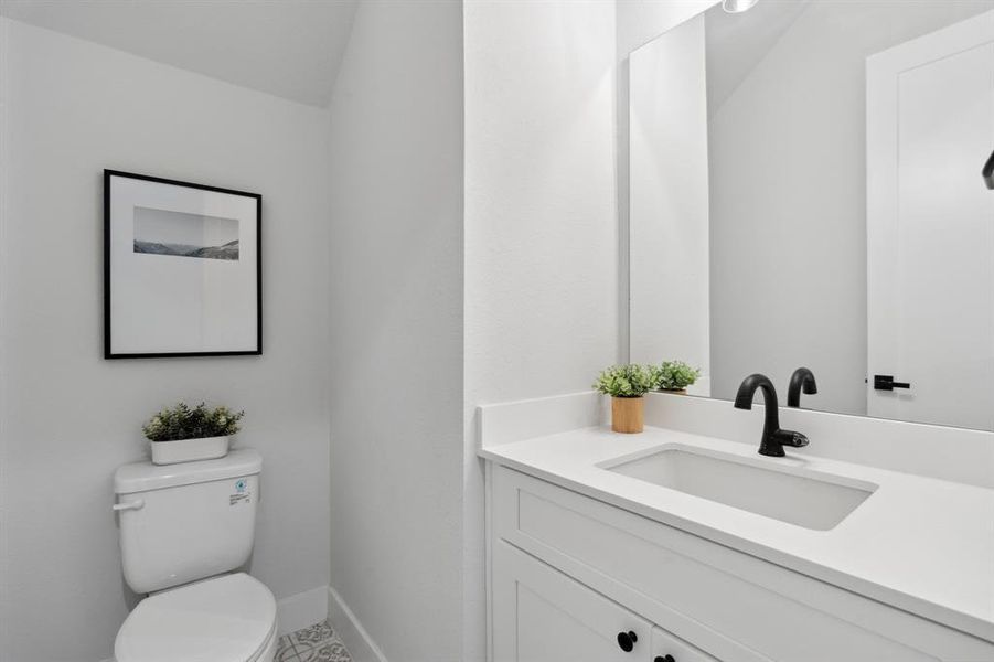 The powder room continues the home's narrative with its polished black hardware, an aesthetic echo of consistency.