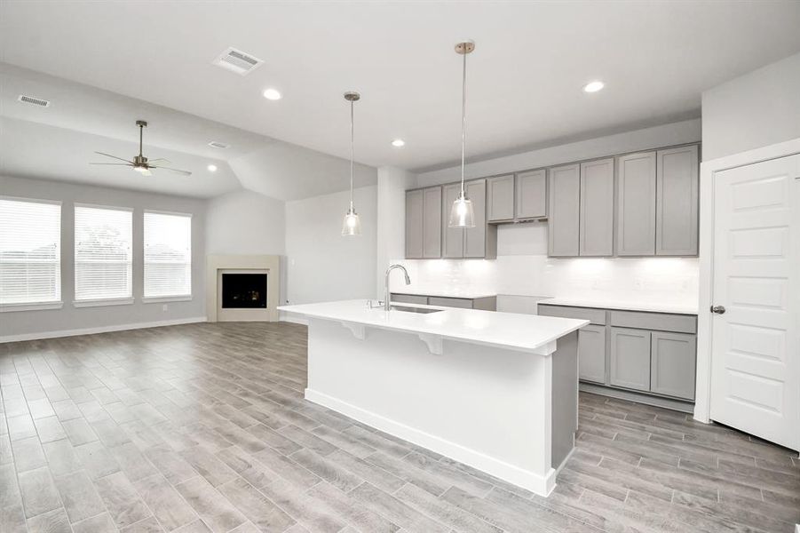 Dream kitchen that exceeds expectations! This generously spacious layout boasts a massive granite island, high ceilings, soft-close cabinets, granite countertops, stainless steel appliances, a sleek tile backsplash, and recessed lighting. The open concept seamlessly connects this culinary haven to the expansive family room, creating the perfect hub for gatherings. Sample photo of completed home with similar floor plan. As-built interior colors and selections may vary.