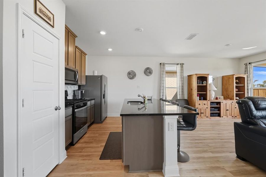 Kitchen with a kitchen breakfast bar, stainless steel appliances, open floor plan, a center island with sink, and plenty of natural light Kitchen with a kitchen breakfast bar, stainless steel appliances, open floor plan, a center island with sink, and plenty of natural light