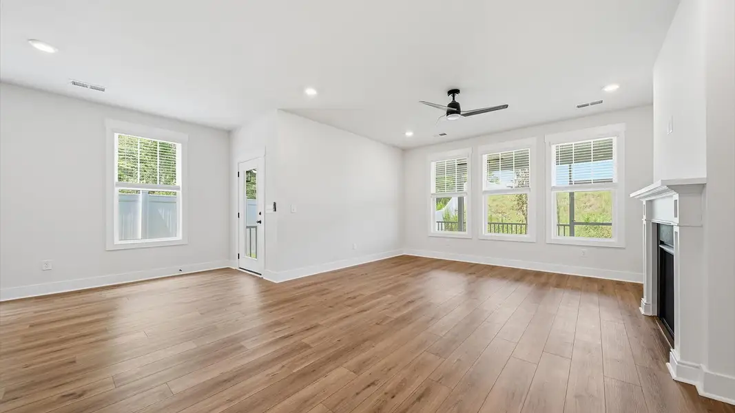 Elegant family room featuring hardwood flooring, large windows, and thoughtful architectural detail