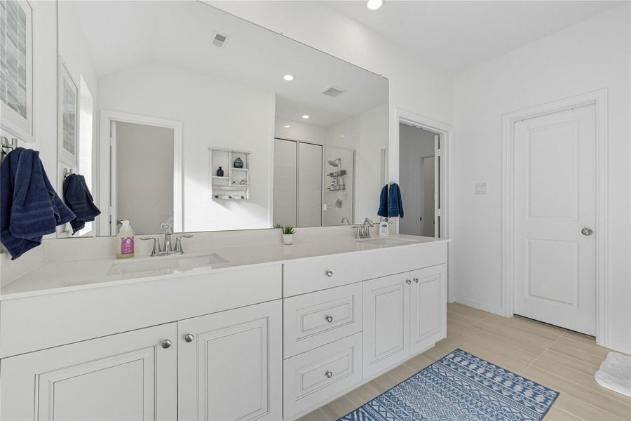 The master bath features a clean, modern design with a double vanity, ample cabinet storage, and a large mirror. The master bath features a clean, modern design with a double vanity, ample cabinet storage, and a large mirror.