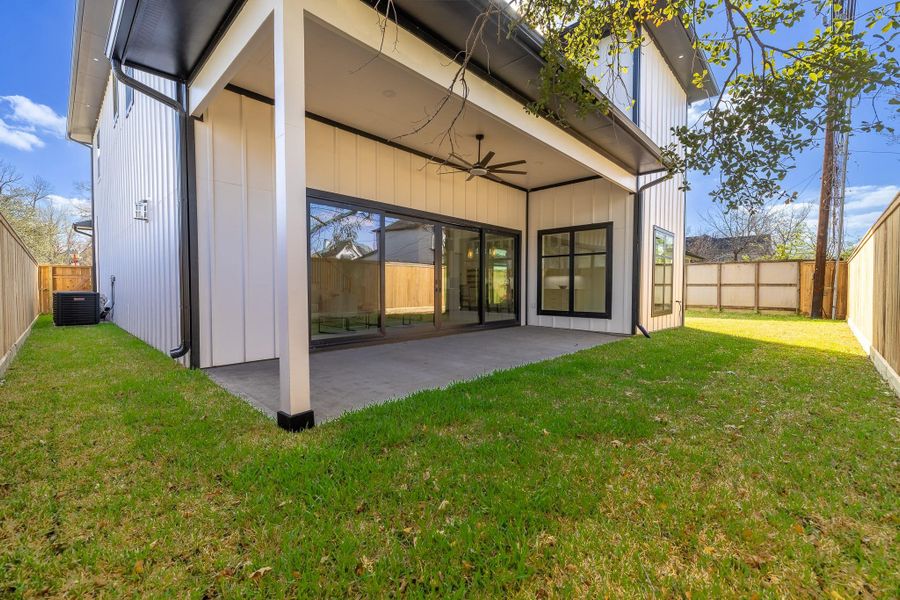 Private backyard with covered patio and green space, offering a low-maintenance outdoor setting ideal for relaxing or entertaining.