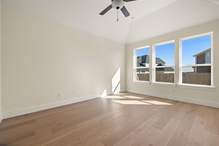 A luminous living space features vaulted ceilings, wide plank hardwood floors, and large windows inviting ample daylight. A luminous living space features vaulted ceilings, wide plank hardwood floors, and large windows inviting ample daylight.