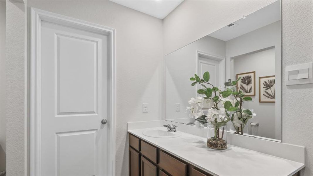 Bathroom with a textured wall and vanity