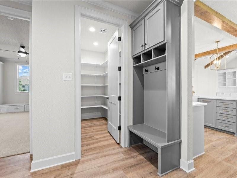 Mudroom with light wood-type flooring, beamed ceiling, and a chandelier
