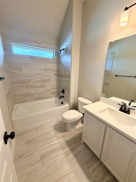 Bath 2 with window has 12x24 tile, white cabinets & Calacatta Lincoln quartz.