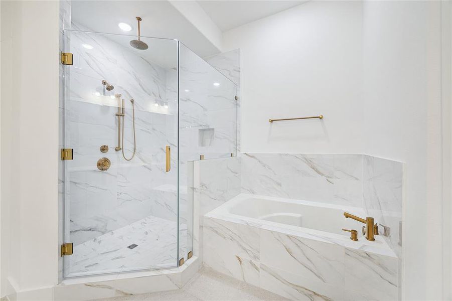 Expansive primary suite bathroom with upgraded Shaker style, soft close cabinets, Designer tile, a freestanding soaking tub, and double sinks. Large walk-in closet is located off the primary bathroom.