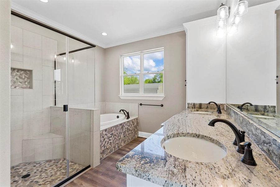 Bathroom with vanity, ornamental molding, hardwood / wood-style floors, and plus walk in shower