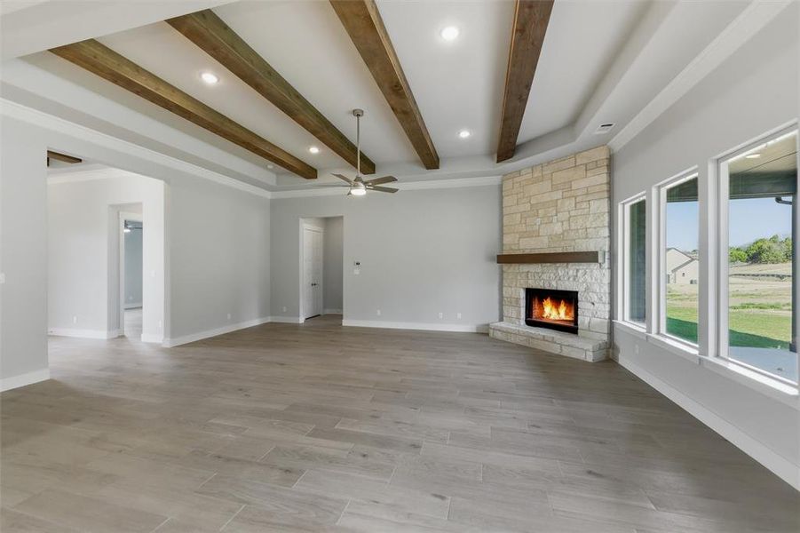Unfurnished living room with recessed lighting, a fireplace, beamed ceiling, light wood-style floors, and ceiling fan