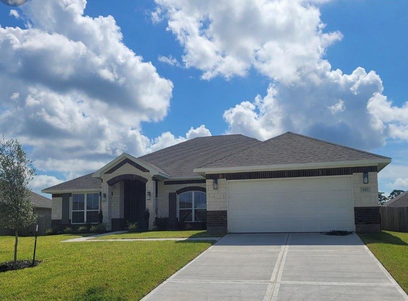 This is a modern, single-story home with a two-car garage and a well-maintained front yard. It features a charming entryway with brick and stone accents under a clear blue sky. Perfect for families seeking a stylish and comfortable living space. This is a modern, single-story home with a two-car garage and a well-maintained front yard. It features a charming entryway with brick and stone accents under a clear blue sky. Perfect for families seeking a stylish and comfortable living space.