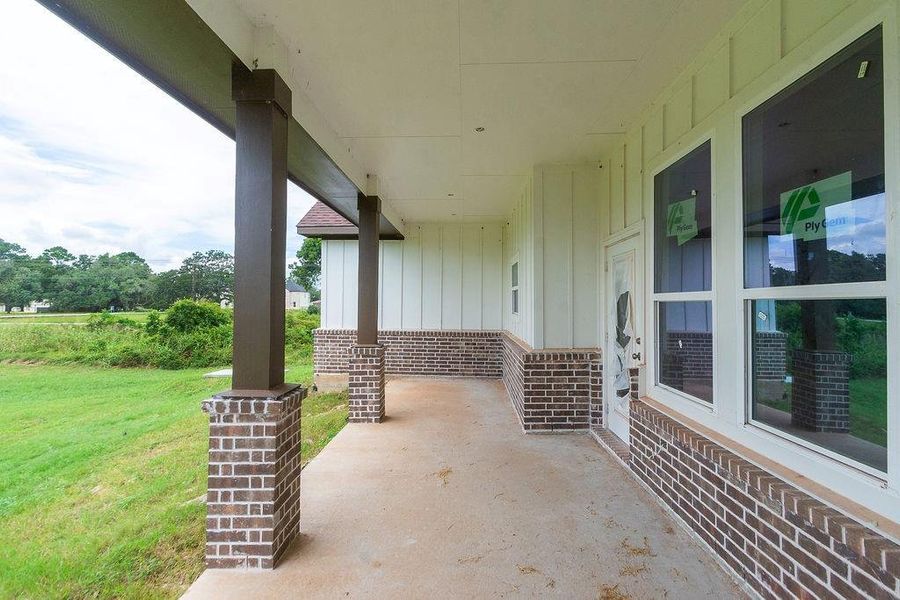 Spacious covered porch with elegant brick columns and serene views of lush greenery, perfect for relaxing or entertaining. Spacious covered porch with elegant brick columns and serene views of lush greenery, perfect for relaxing or entertaining.