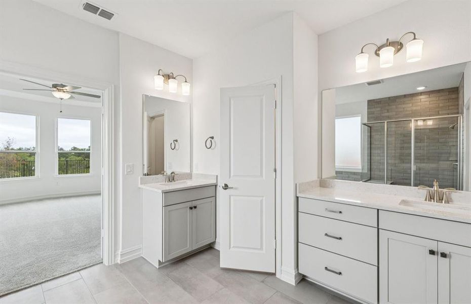 Modern owner's bath with dual vanities and a spacious shower  *Real home pictured