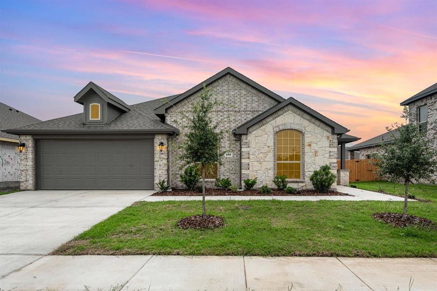 French country inspired facade featuring a garage and a lawn