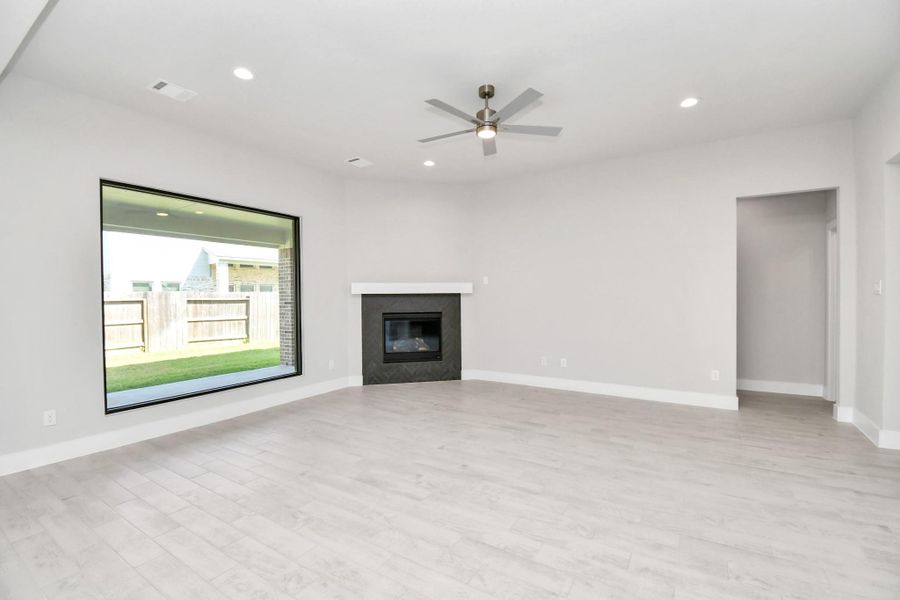 Family room flooded with natural light through the expansive windows. The premium tile flooring adds a touch of luxury to the space, creating the perfect setting for relaxing moments and cherished gatherings with loved ones. Sample photo of completed home with similar floor plan. Actual colors and selections may vary. Family room flooded with natural light through the expansive windows. The premium tile flooring adds a touch of luxury to the space, creating the perfect setting for relaxing moments and cherished gatherings with loved ones. Sample photo of completed home with similar floor plan. Actual colors and selections may vary.