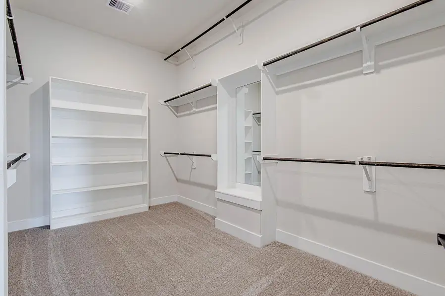 Large walk-in closet with built-in shelving for optimal storage.