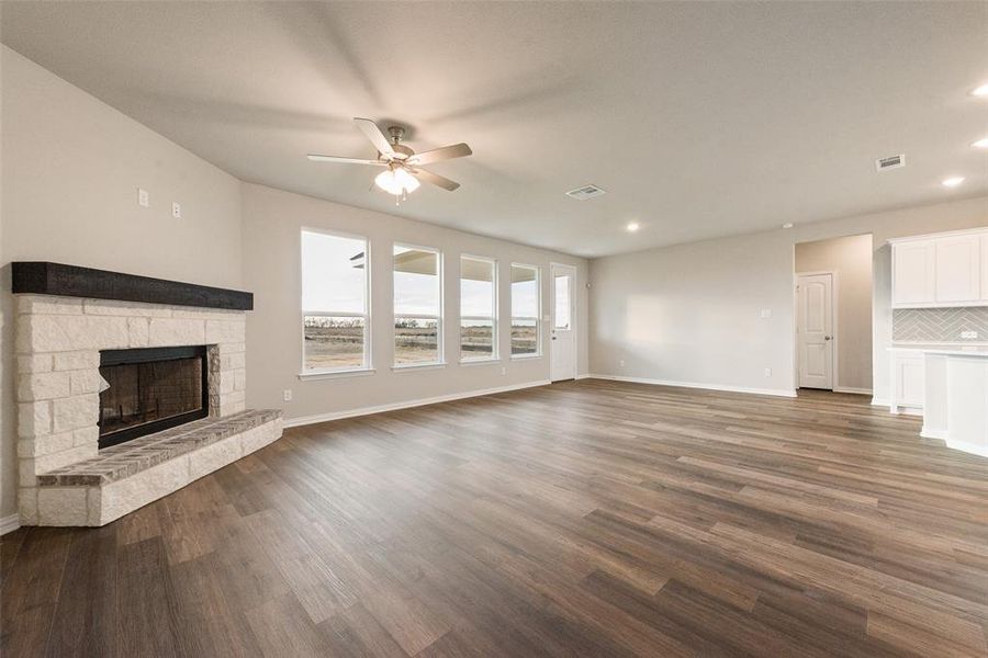 Unfurnished living room featuring dark wood-style floors, a fireplace, a ceiling fan, and recessed lighting