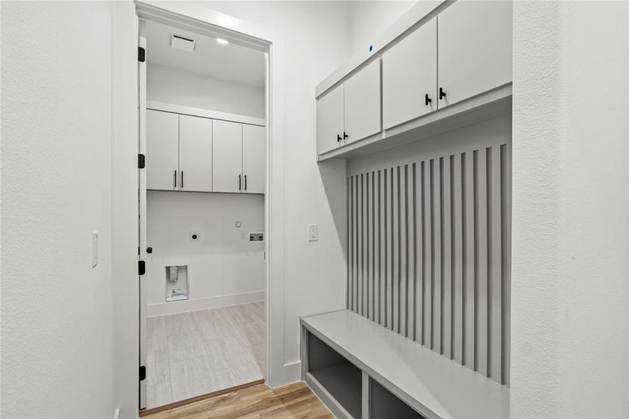 Mudroom with light wood finished floors and baseboards