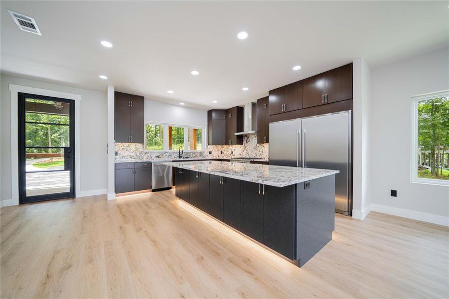 Kitchen with stainless steel appliances, a center island, plenty of natural light, backsplash, and recessed lighting Kitchen with stainless steel appliances, a center island, plenty of natural light, backsplash, and recessed lighting