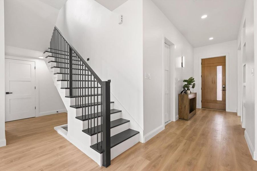 Foyer with light wood-style floors, recessed lighting, and stairs Foyer with light wood-style floors, recessed lighting, and stairs