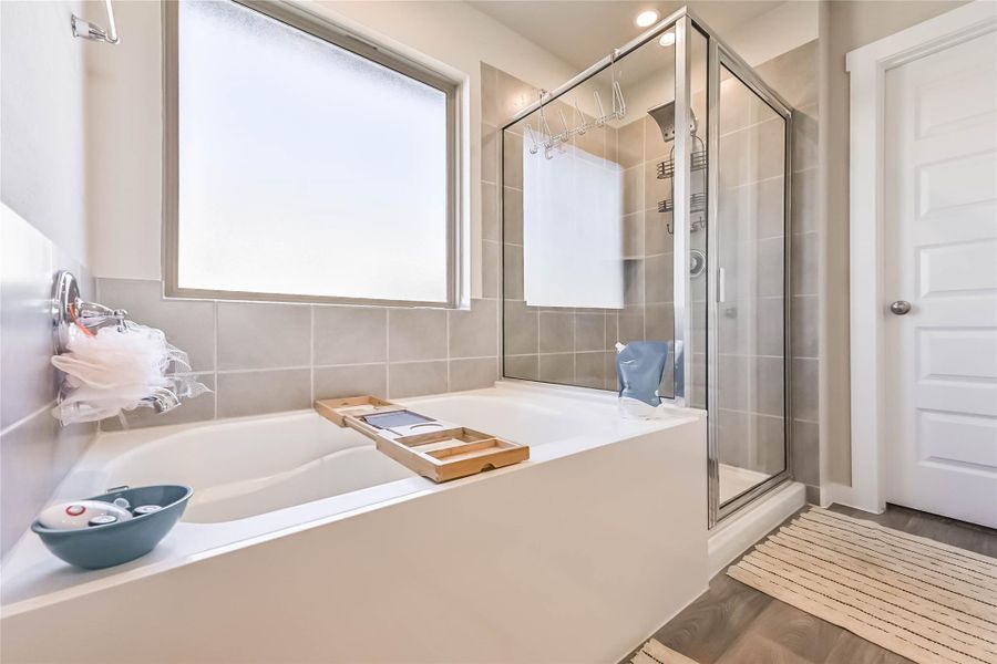 Private primary bath with soaking tub/shower combo, dual sinks, private toilet area, and walk-in closet.