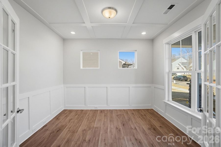 Office with faux coffered ceiling, French doors, and wainscoting
