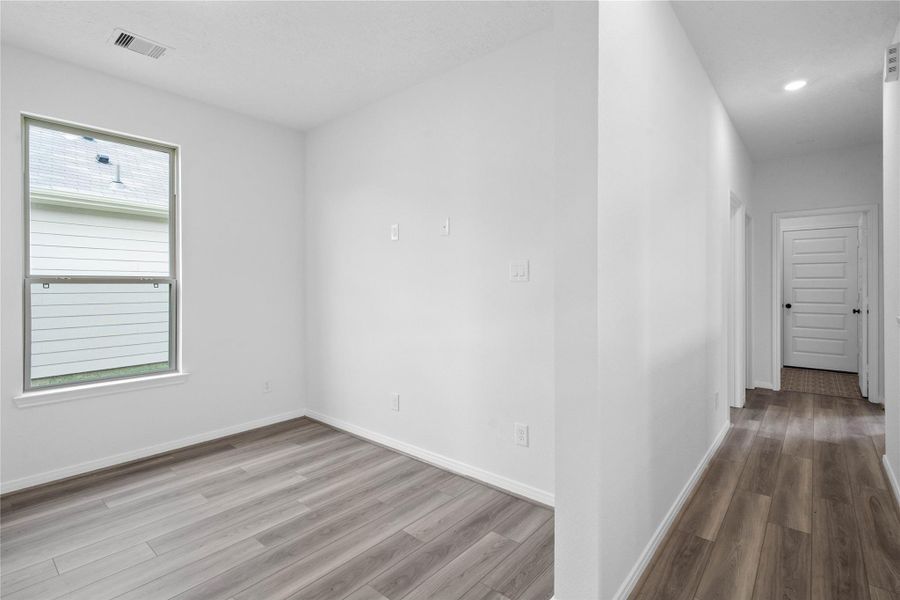 From the Den into the hallway leading you to the secondary bedrooms, bathroom, and laundry room.