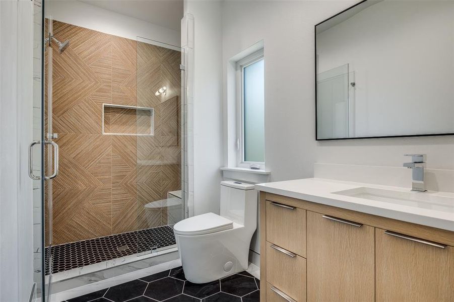 Full bathroom with vanity, dark tile patterned flooring, and a shower stall Full bathroom with vanity, dark tile patterned flooring, and a shower stall