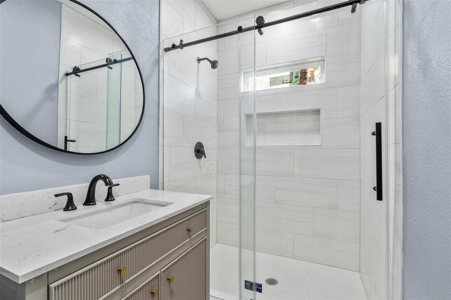 Bathroom with vanity and a shower with shower door