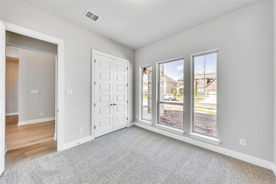 Unfurnished bedroom with light carpet and a closet Unfurnished bedroom with light carpet and a closet