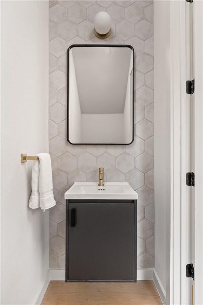 Half bathroom featuring vanity and light wood-style flooring