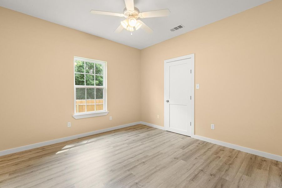 Empty room featuring light wood finished floors and a ceiling fan