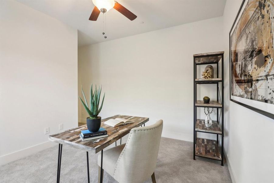 Carpeted office featuring ceiling fan