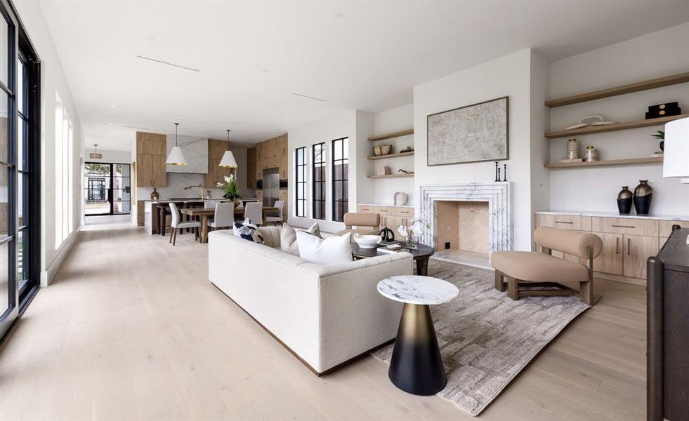 Living room featuring a high end fireplace and light wood-type flooring