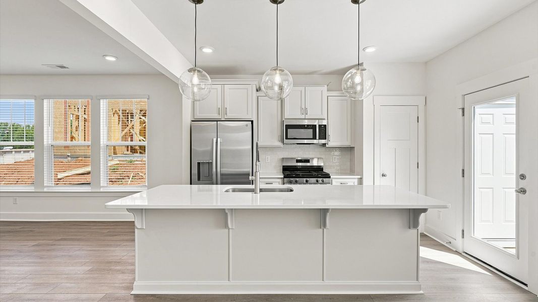 Memorable meals begin in this vibrant kitchen with pendant lighting and a thoughtfully designed island by DRB Homes Memorable meals begin in this vibrant kitchen with pendant lighting and a thoughtfully designed island by DRB Homes