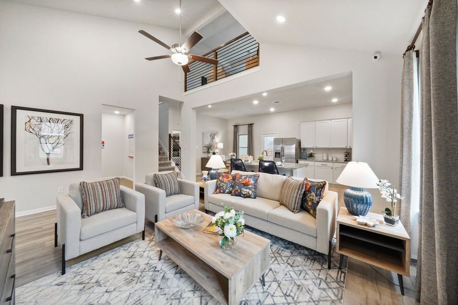 Open-concept living room with vaulted ceiling, loft overlook, and modern furnishings