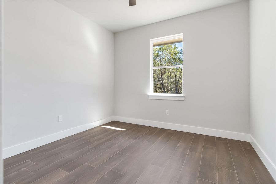 2nd bedroom with ceiling fan facing back of home