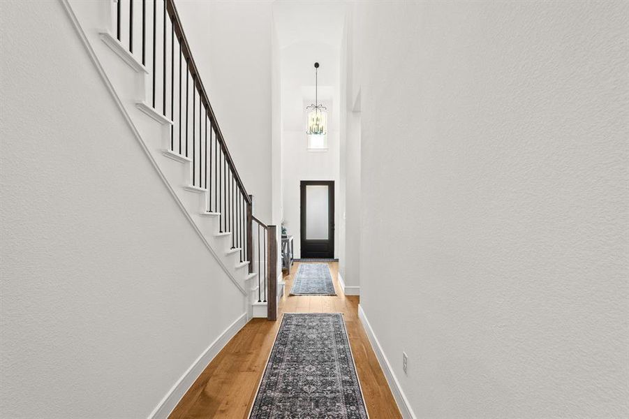 Entryway featuring wood finished floors, stairway, and a high ceiling