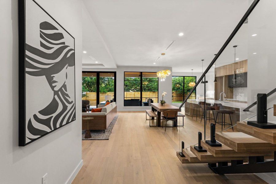 Clean lines and warm wood floors define this open living space with floating stairs.