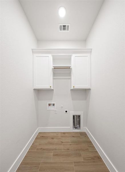 Dedicated laundry room featuring wood-finish tile flooring and crisp white walls Dedicated laundry room featuring wood-finish tile flooring and crisp white walls