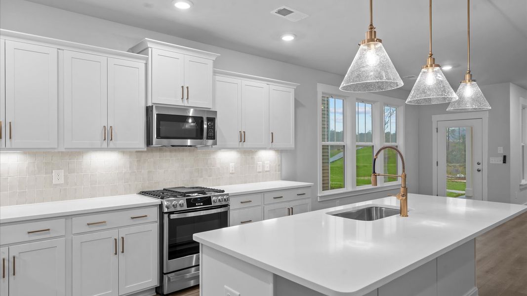 Highly skilled craftsmanship shines in this modern kitchen with pendant lighting and a central island focal point Highly skilled craftsmanship shines in this modern kitchen with pendant lighting and a central island focal point