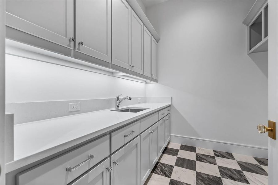 Washroom featuring sink and light tile flooring