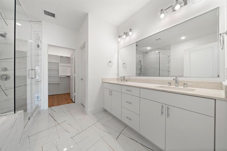 The other side of the primary bathroom has double sinks, and you can see the large master closet in the background.