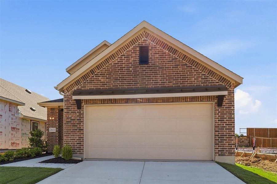 Brick exterior with light-colored garage door and dark wood-look accents