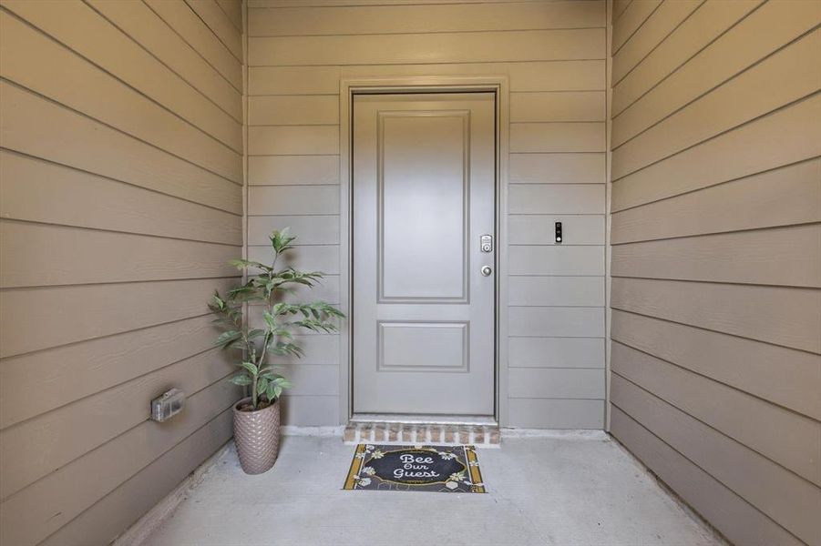 Front entry with welcome mat and greenery-staged
