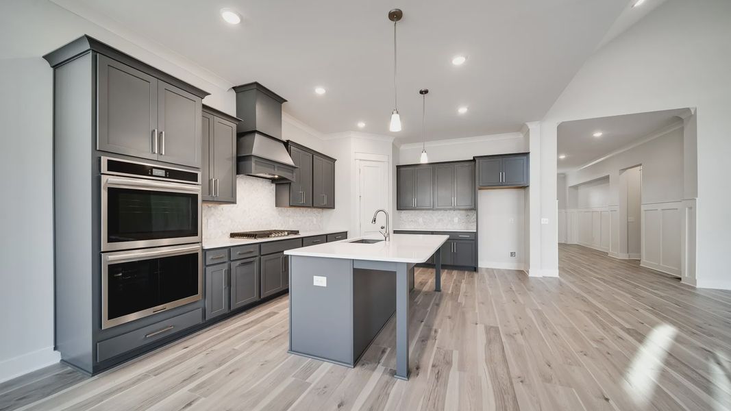 Modern kitchen with island, gray cabinets, and tile backsplash
