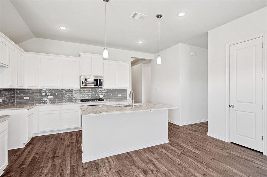 Kitchen with sink, a center island with sink, dark hardwood / wood-style flooring, and white cabinetry