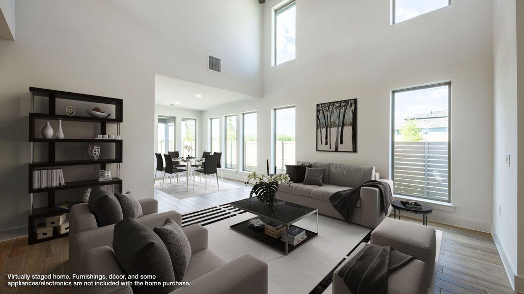 Living area featuring wood finished floors and a towering ceiling Living area featuring wood finished floors and a towering ceiling