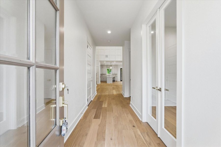 Step inside through the 8-foot front door into a spacious foyer filled with natural light, sleek hardwood flooring, and a dedicated home office just off to the right.