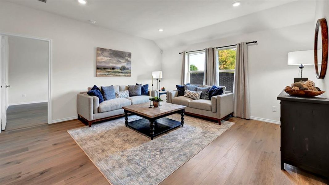 Living area with recessed lighting, light wood finished floors, and lofted ceiling