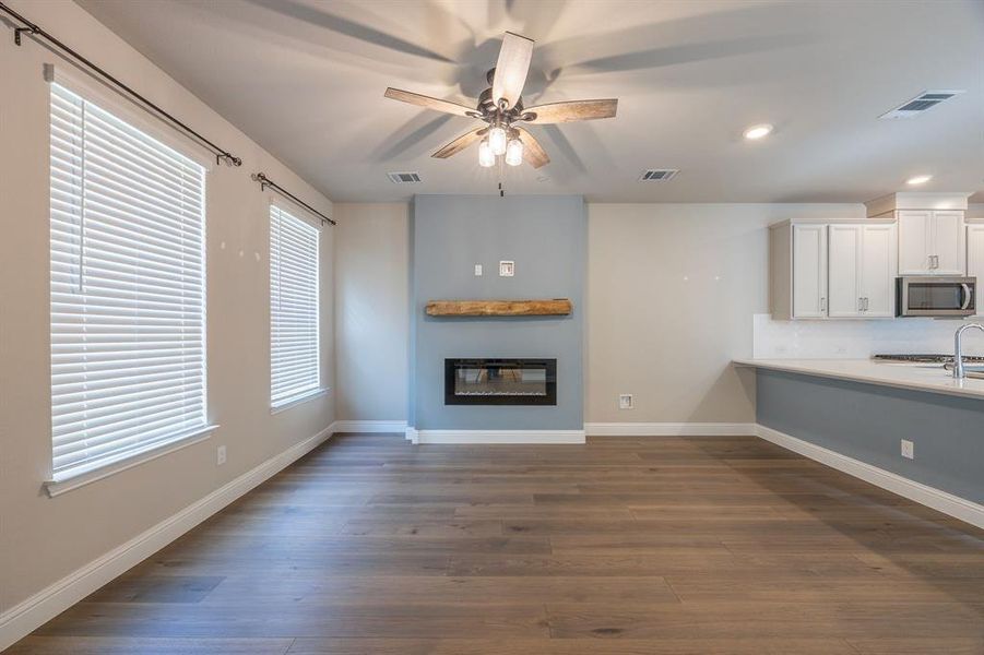 Move in ready living area with celing fan, gas fireplace, window blinds and engineered wood flooring - View